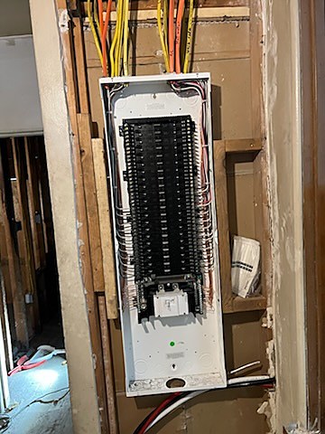 A new load center set into a basement wall during a residential service upgrade